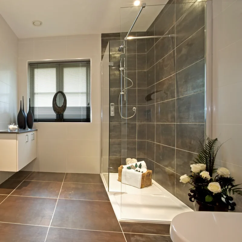 Helles, modernes Badezimmer mit barrierearmer Dusche, Glasabtrennung und komfortabler Ausstattung.